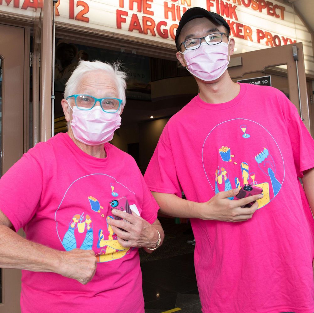 Two Queer Screen volunteers outside a cinema