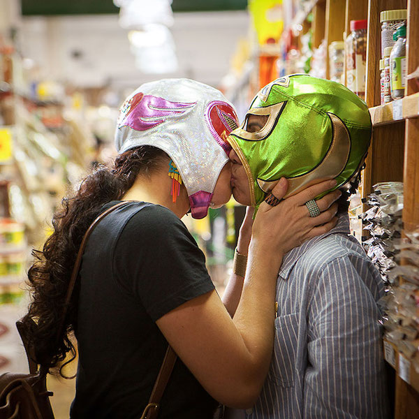 Two women in luche libre masks kiss