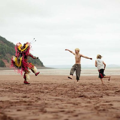 Three young people dancing on the beach