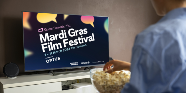 A TV screen that has the MGFF24 logo and speech bubble design on it. Someone is sitting in front of the tv with popcorn.