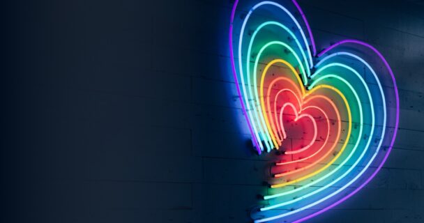 rainbow coloured neon lights in the shape of a love heart