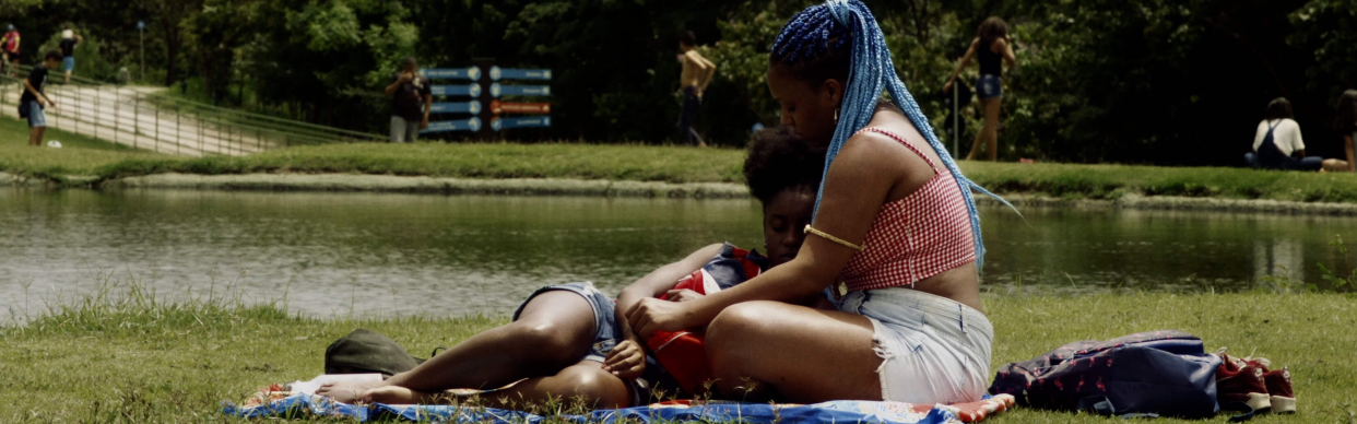 Nina and Joana lay together on the grass by a lake in the film Mars One.