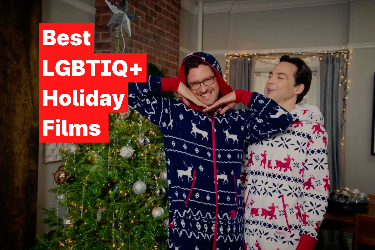 Two tall men with brown hair are wearing Christmas-themed onesies standing next to a Christmas tree and smiling. The text on the side says "Best LGBTIQ+ Holiday Films"