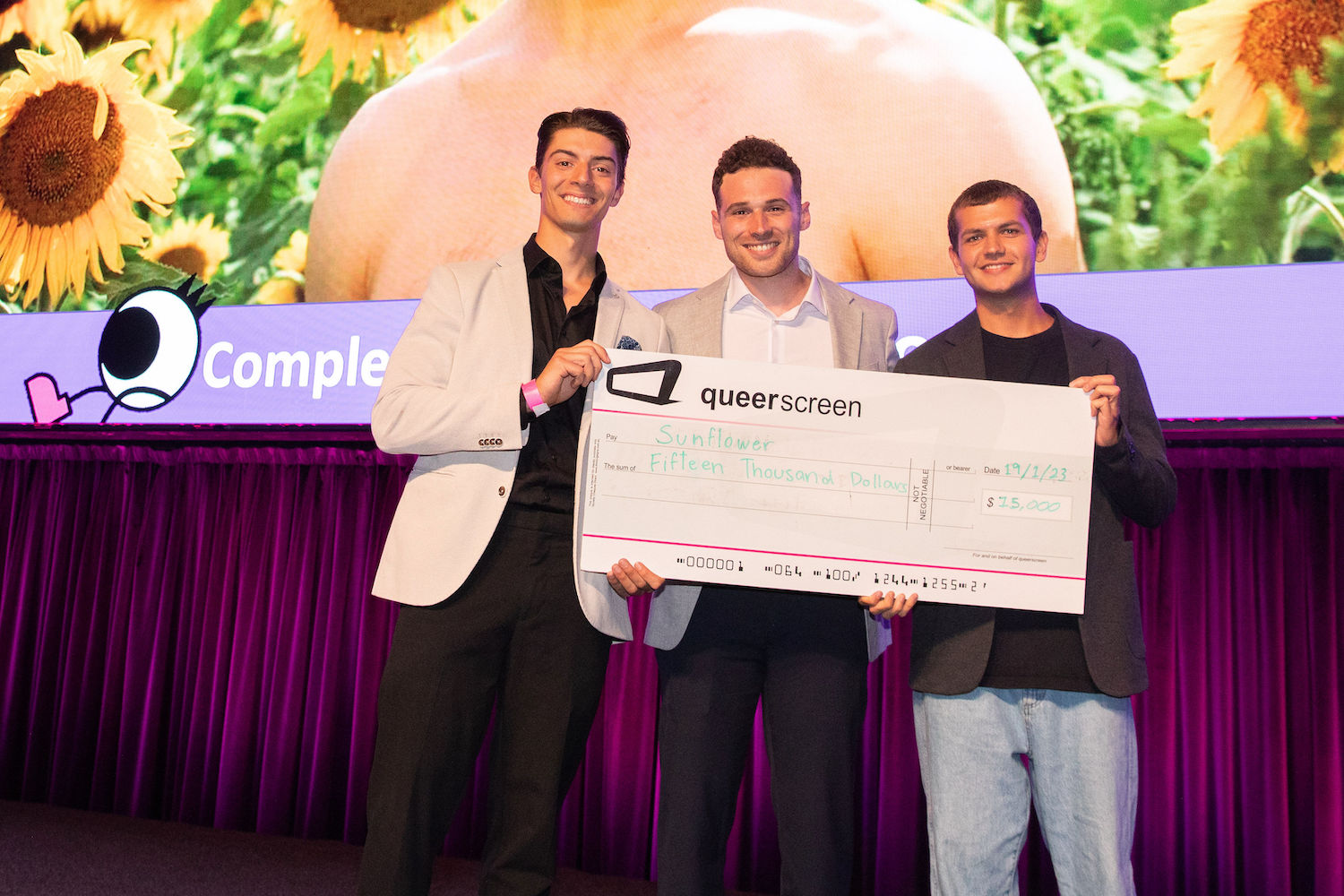 Queer Screen Completion Fund 2023 recipients holding large cheque worth $15,000.