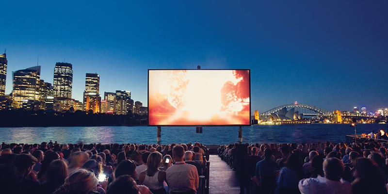 Photograph of Westpac OpenAir Cinema, showing a large cinema screen in Sydney harbour overlooking the city.