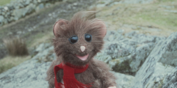 A little puppet animal wearing a red scarf.