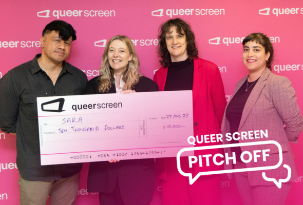 Four people against a pink wall with a giant cheque