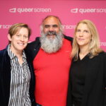 Three people in front of a pink background
