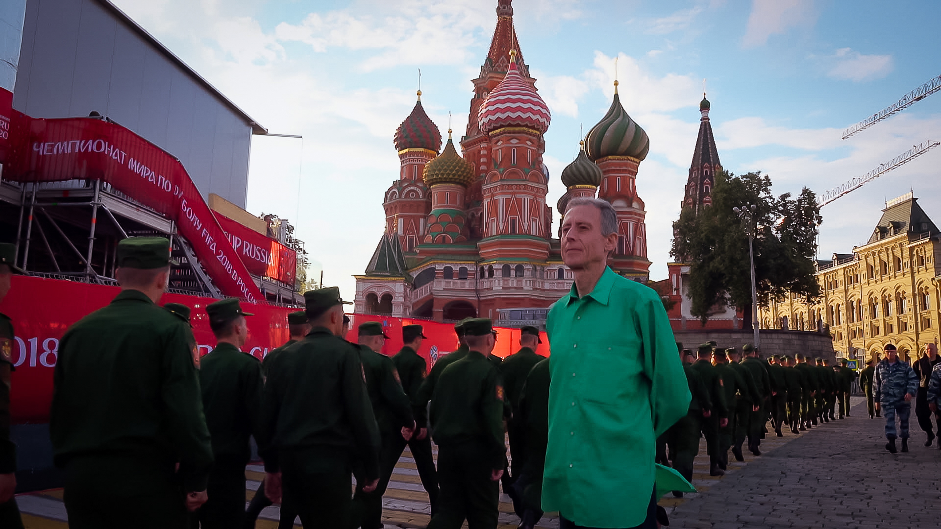 A man in a green shirt stands next to soldiers in Russia