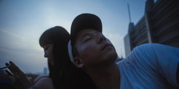 A person resting their head on someones shoulder. Their face is up to the sky and their eyes are closed.
