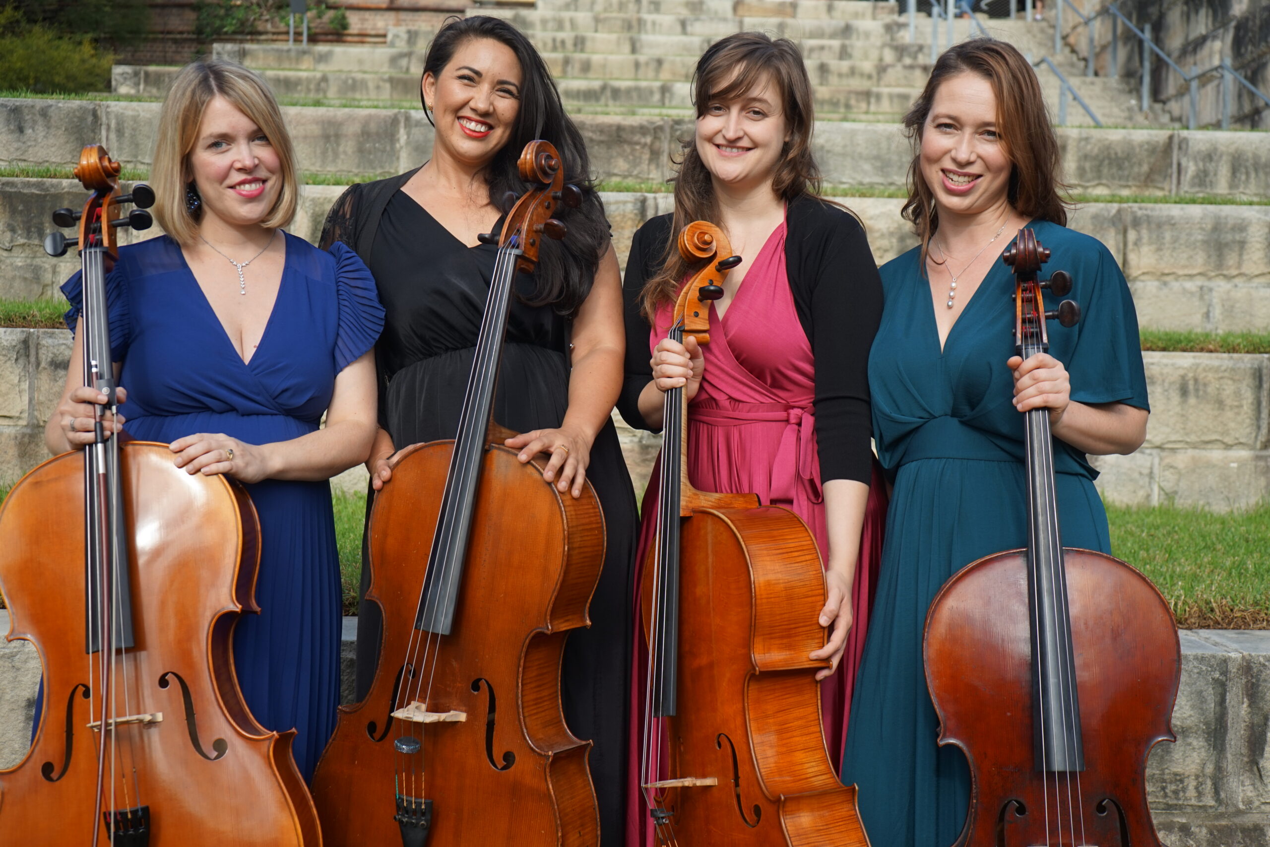 A photo of four people with their cellos, the members of the Sydney Cello Quartet.