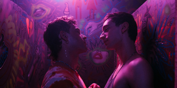 A still from the film 'Solo'. Two people in what appears to be a club bathroom. They are standing close together, looking into each other's eyes.