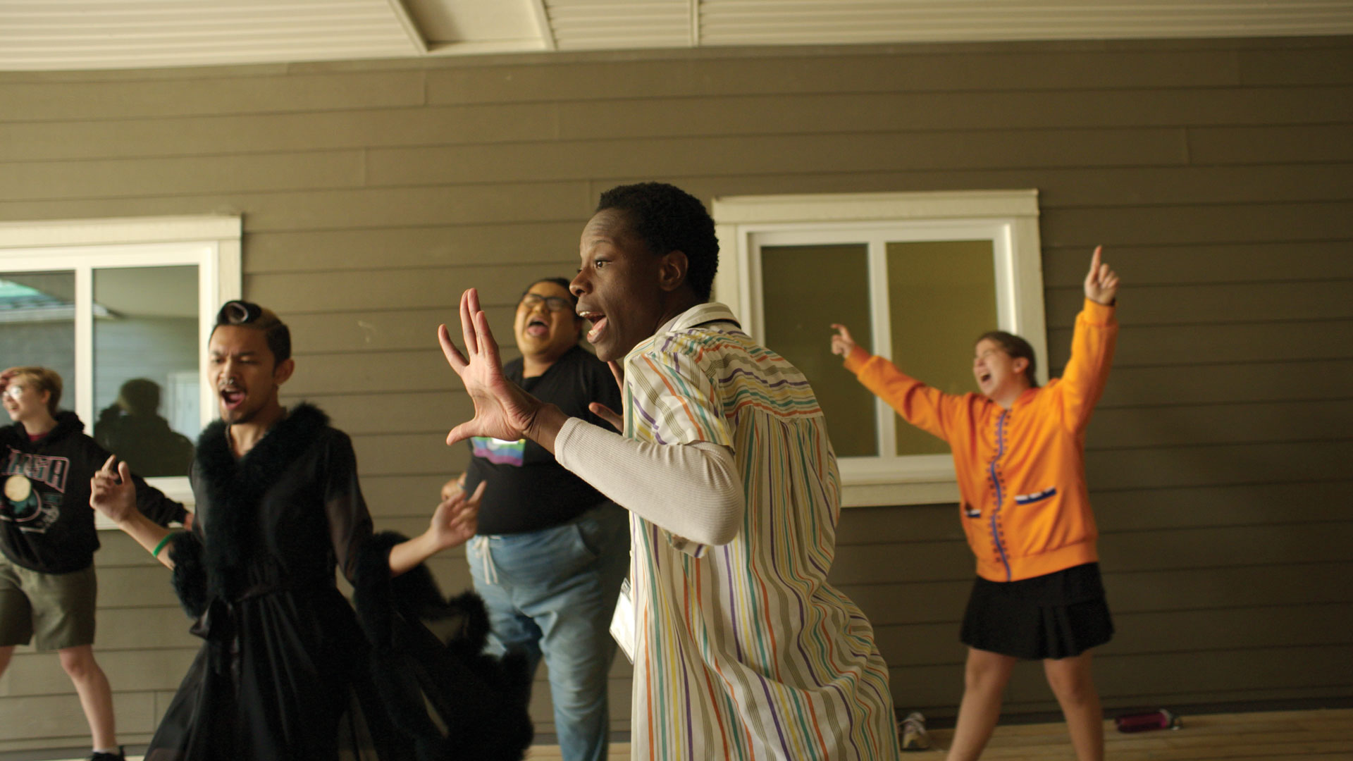 A group of young people dance joyfully.